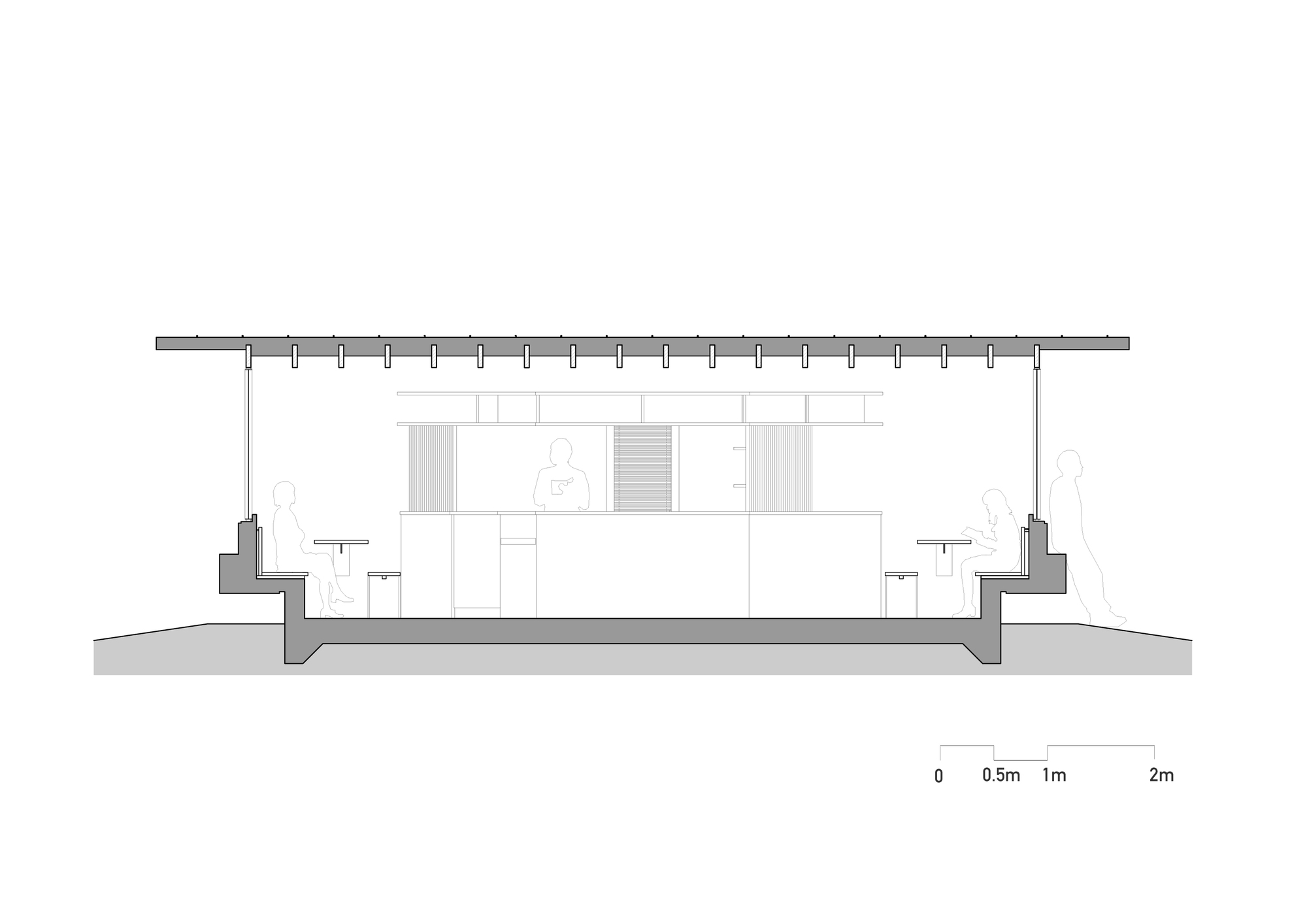 Long section drawing of the pavilion showing a sunken floor, tiered bench seating at both ends, a central counter and seated figures