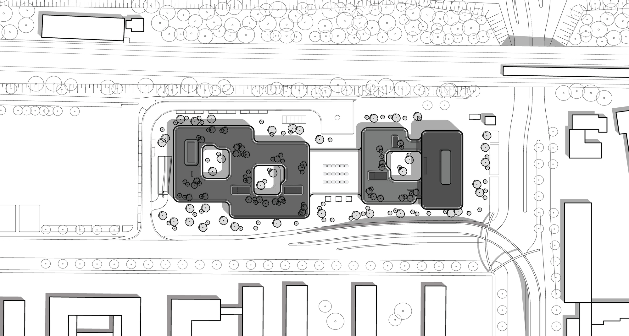 Site plan drawing showing two building masses with courtyard voids, surrounding trees, a road curve and neighbouring blocks