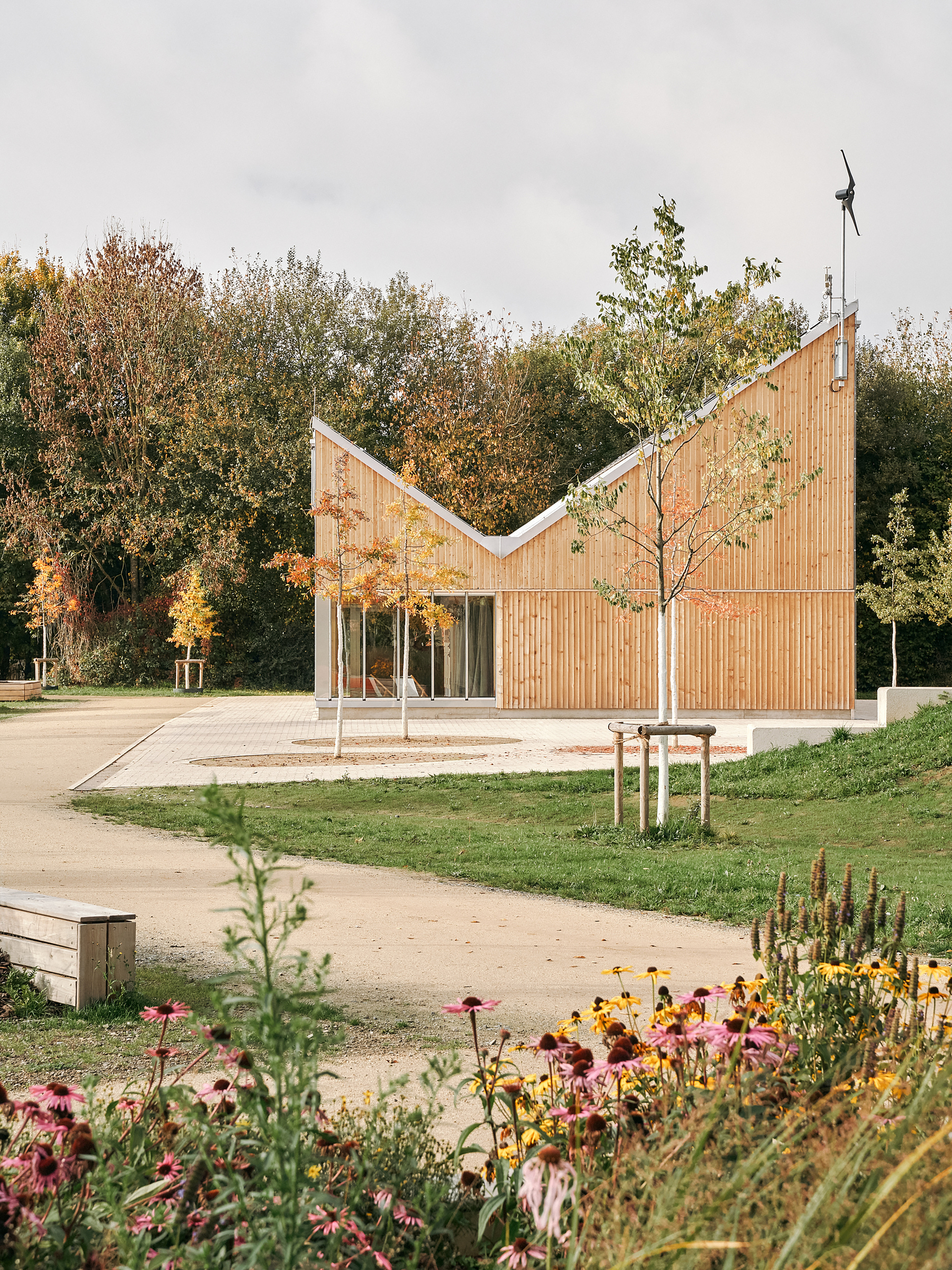 View of the pavilion across the surrounding wildflower meadow and gravel paths