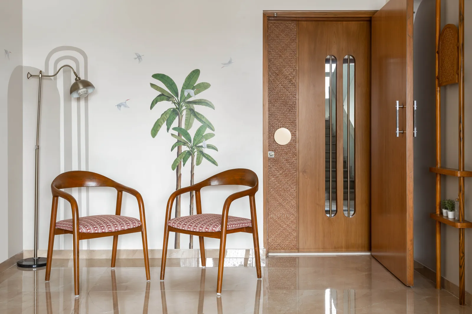 The wall adjacent to the dining flaunts a decal of coconut trees by Kalakaari Haath that adds to the vivacity of the scenario. The subtle grey arched pattern integrates this corner with the rest of the home. Anuja Kambli