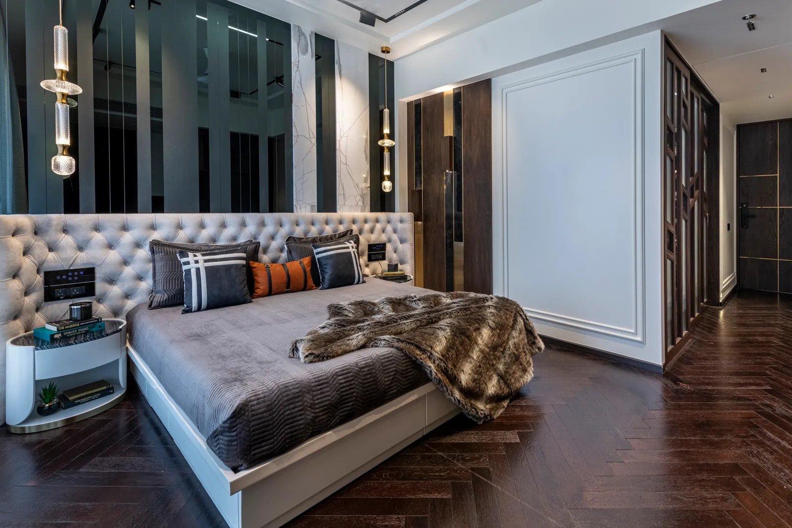 The tour de force of the primary bedroom is the inbuilt alcove seating. The room also opens into a walk-in closet with his-and-hers sections, faux leather shutters, a suspended capsule mirror, and an island counter. PRASHANT BHAT