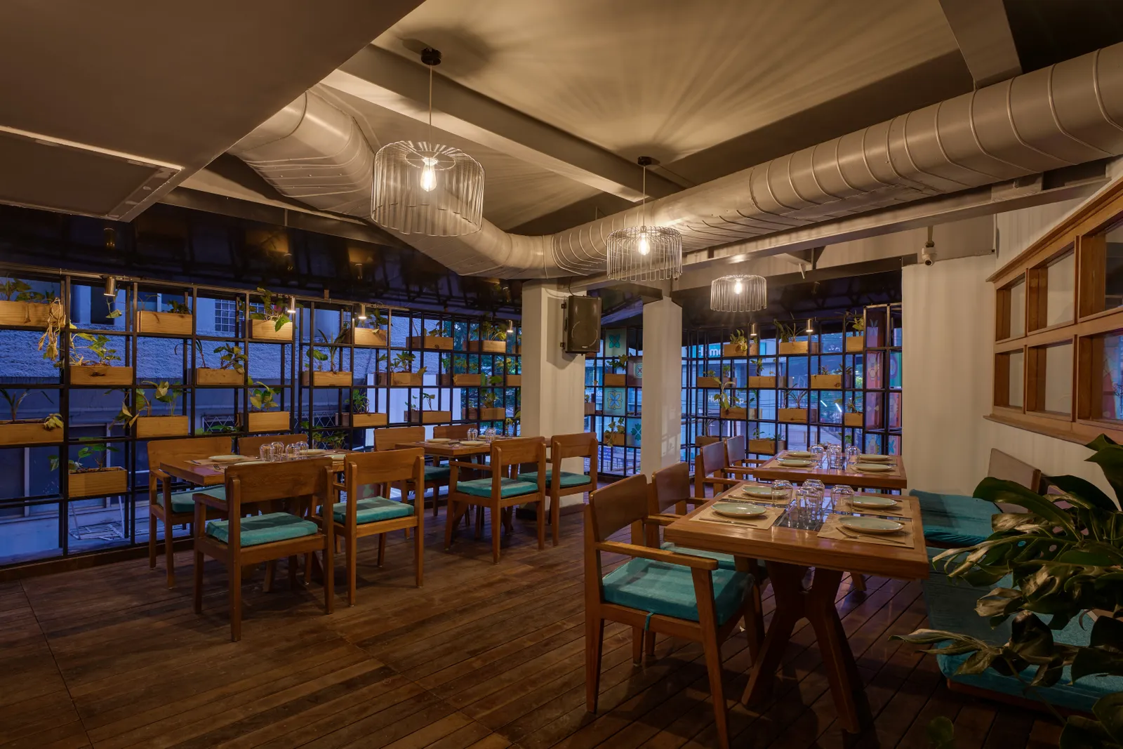 The smoking section features wooden flooring and walls lined with planters. Shamanth Patil