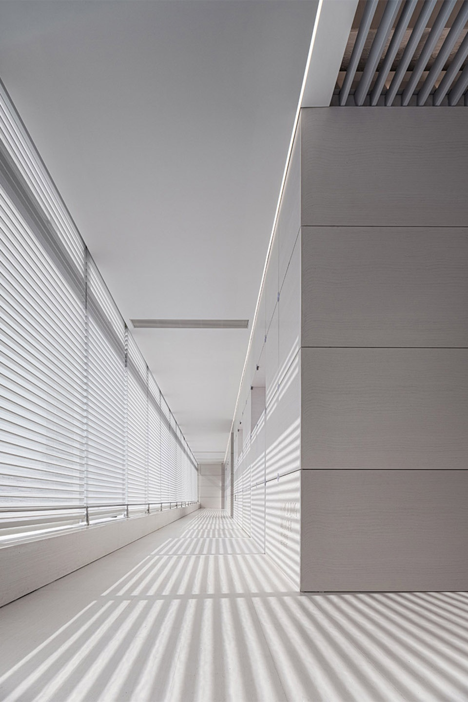 Technological lighting and linear natural light and shadow in the corridor © WYAP