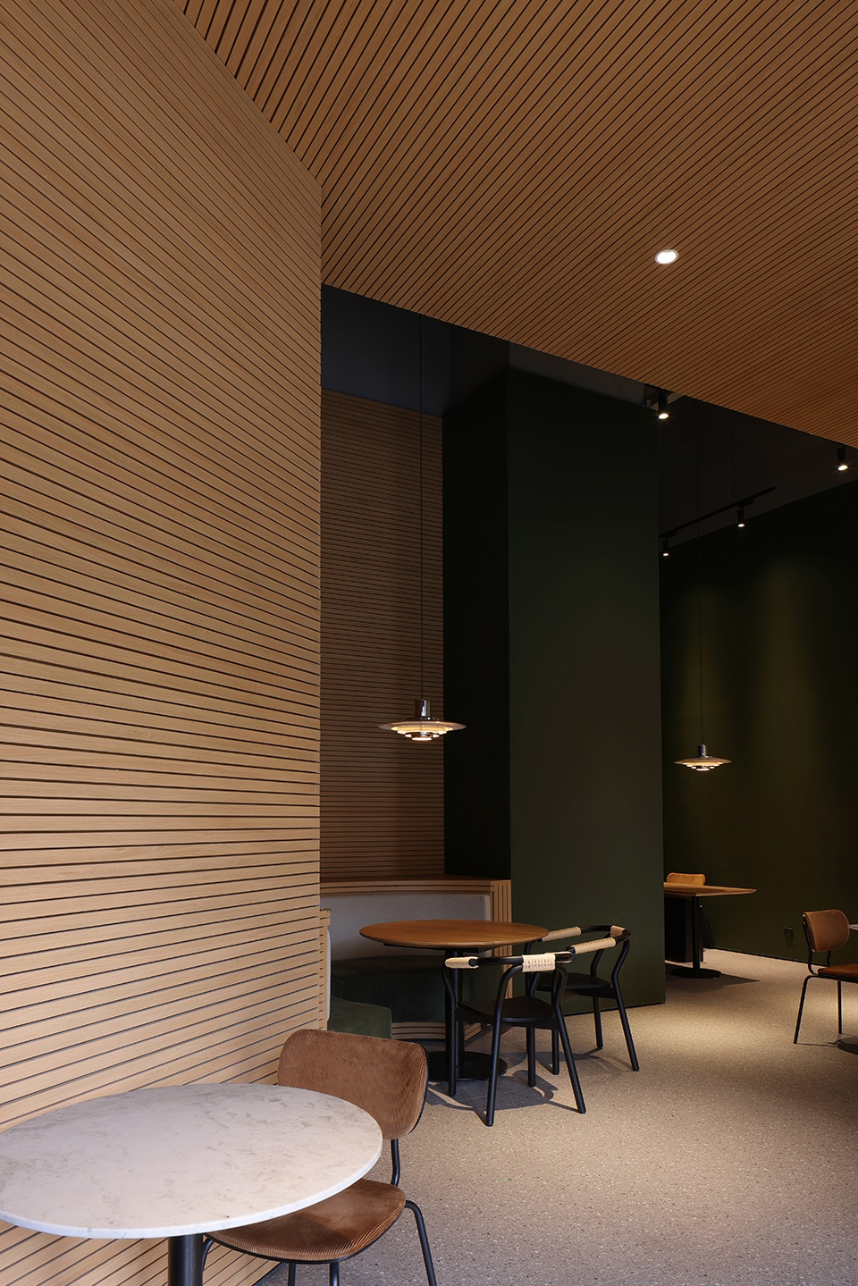  The warm wood colour with the brand's unique dark green is the keynote of the space © Xiao Le 