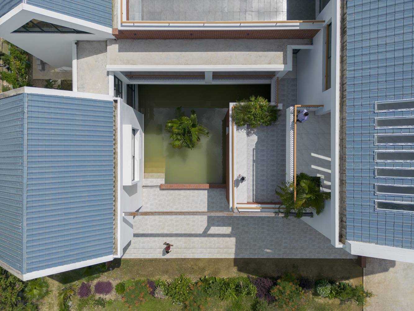 Aerial view of courtyard pool with louvered screens and timber pergola in midday sun